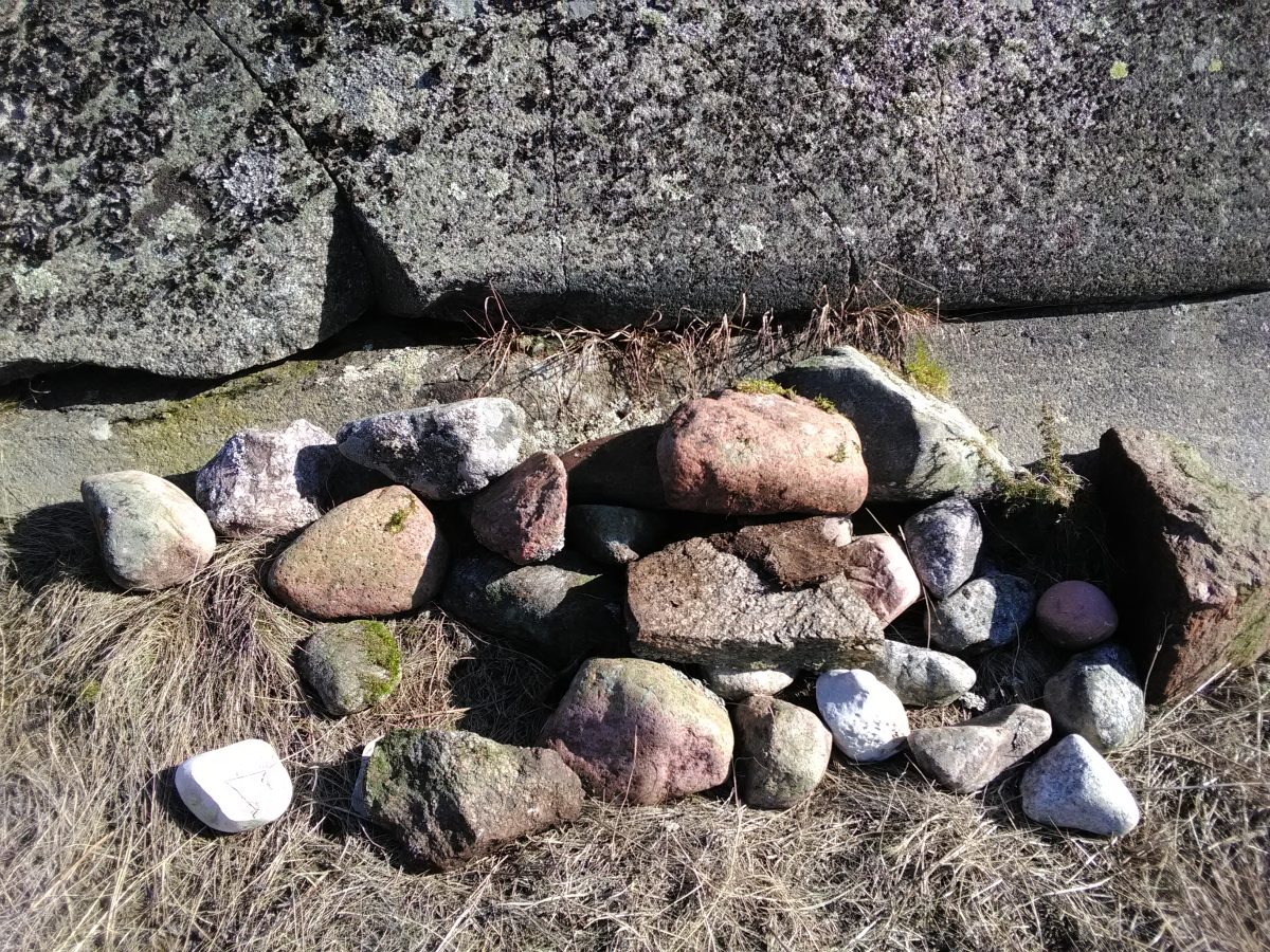 A picture of stones on a sandy beach.